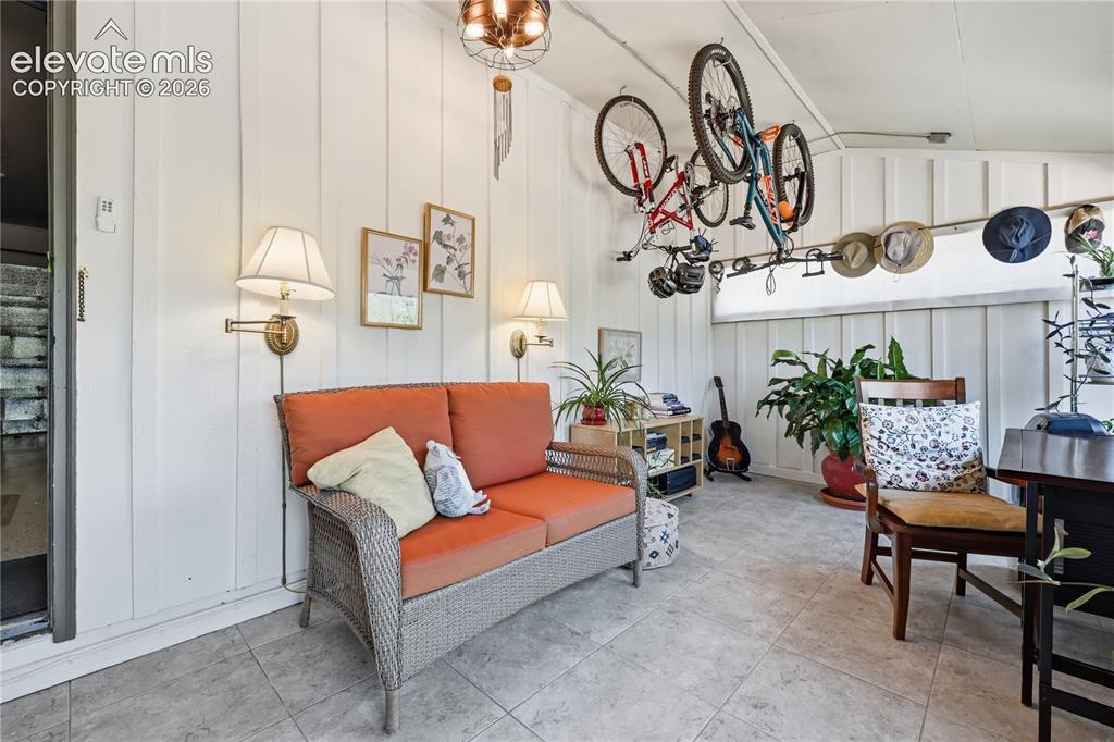 Image 13 of 44: Sun room off of garage and kitchen great secluded space with multiple uses.