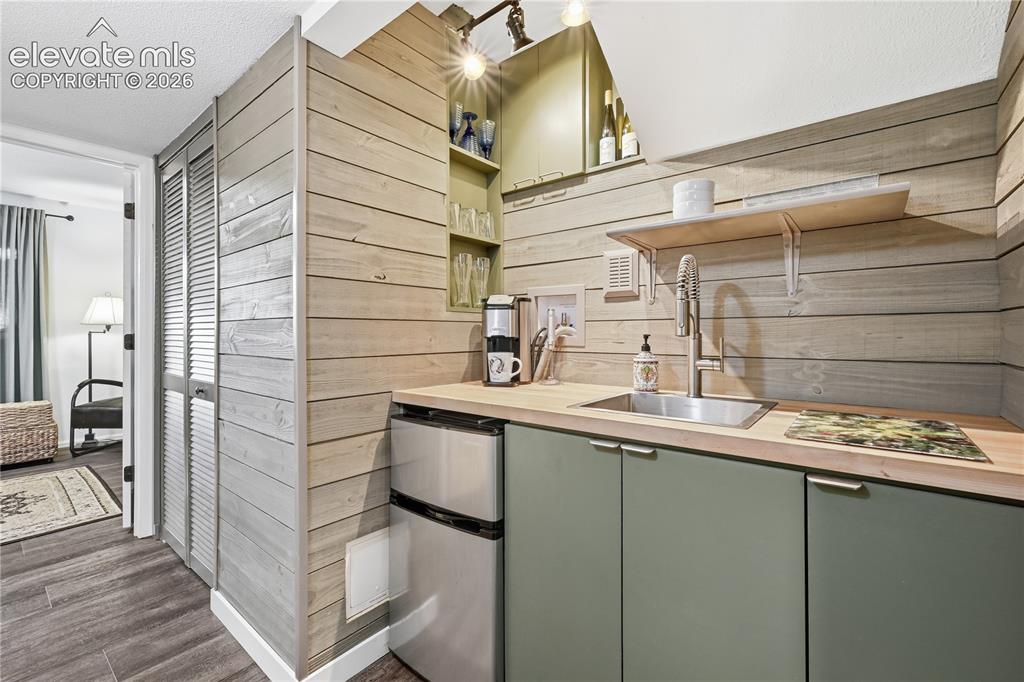Image 24 of 44: Small kitchenette in Lower Level mini fridge, sink, and appliance cabinets 
