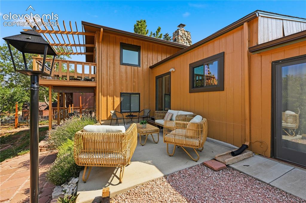 Image 32 of 44: Back patio off of dining area and sun room. and view of upper level deck fr