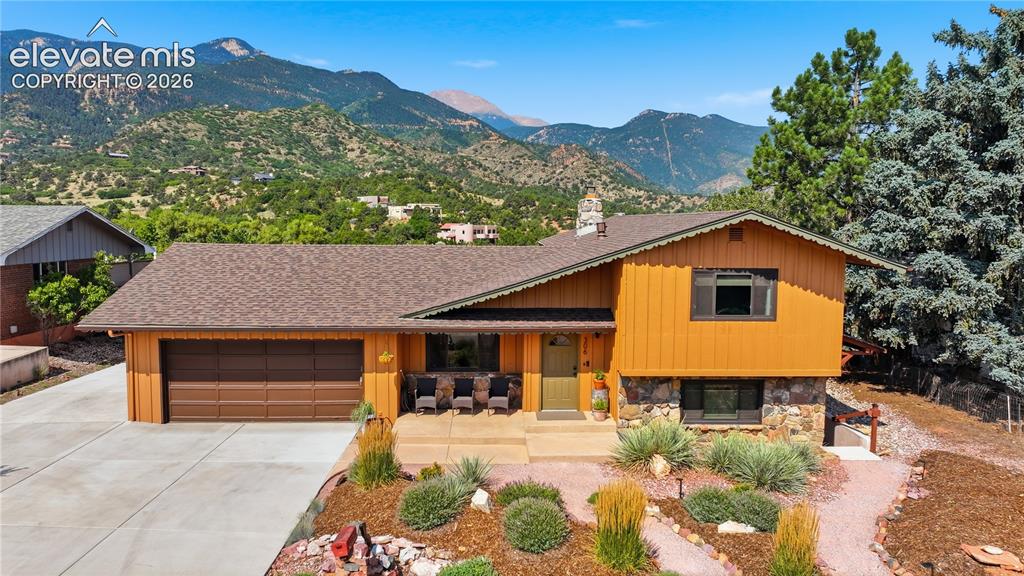Image 36 of 44: Front of home and the views behind, Pikes Peak and The Incline. Very Few h
