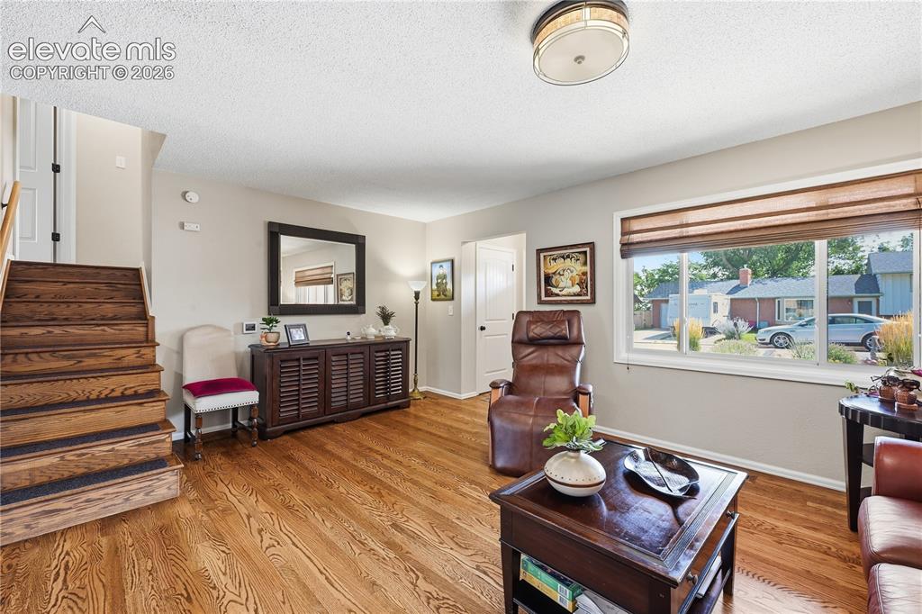 Image 7 of 44: Living room main level view towards entry door and coat closet and stairs t