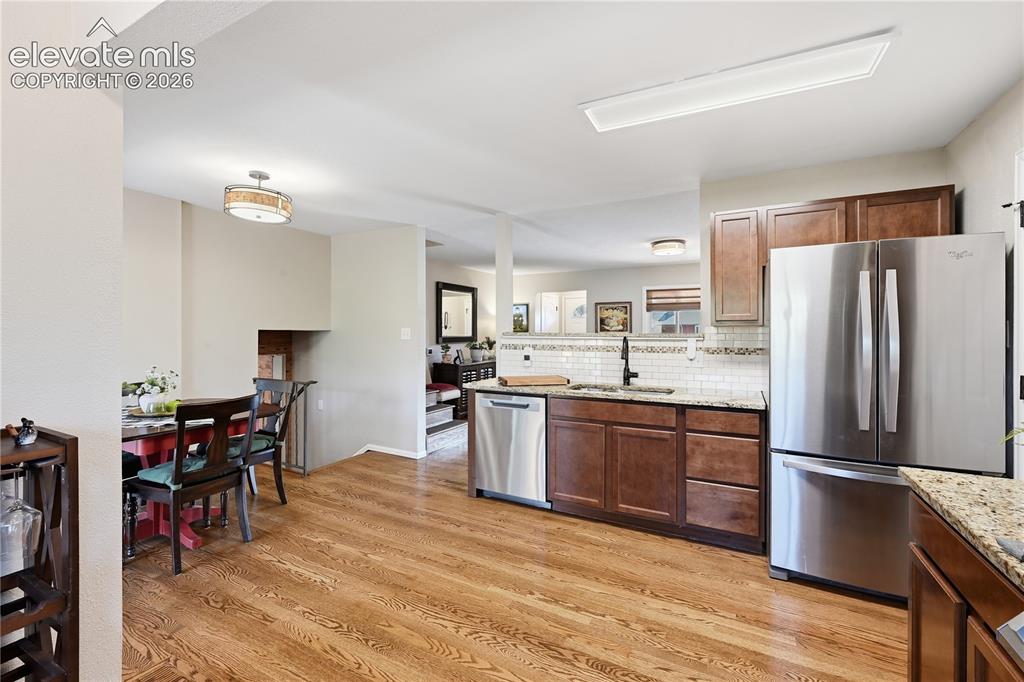 Image 9 of 44: Kitche and dining area in view.  Hardwood floors on main level of home. Sta