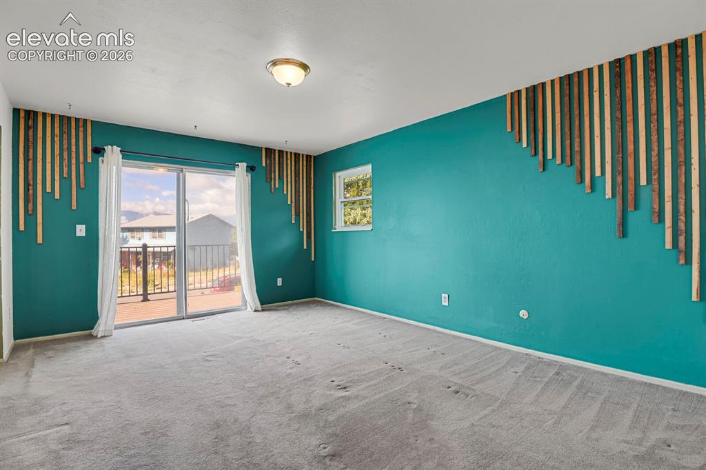 Image 12 of 35: Sliding glass door leading to an outdoor balcony with metal railings