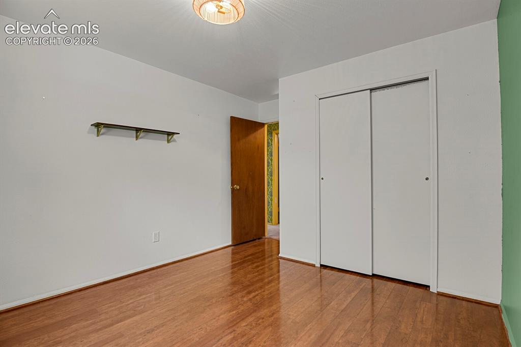 Image 16 of 35: Hardwood flooring, painted walls, ceiling-mounted light fixture, sliding cl