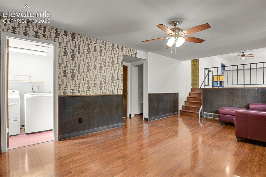 Image 21 of 35: Hardwood-finish flooring, half-wall paneling, built-in staircase, ceiling f