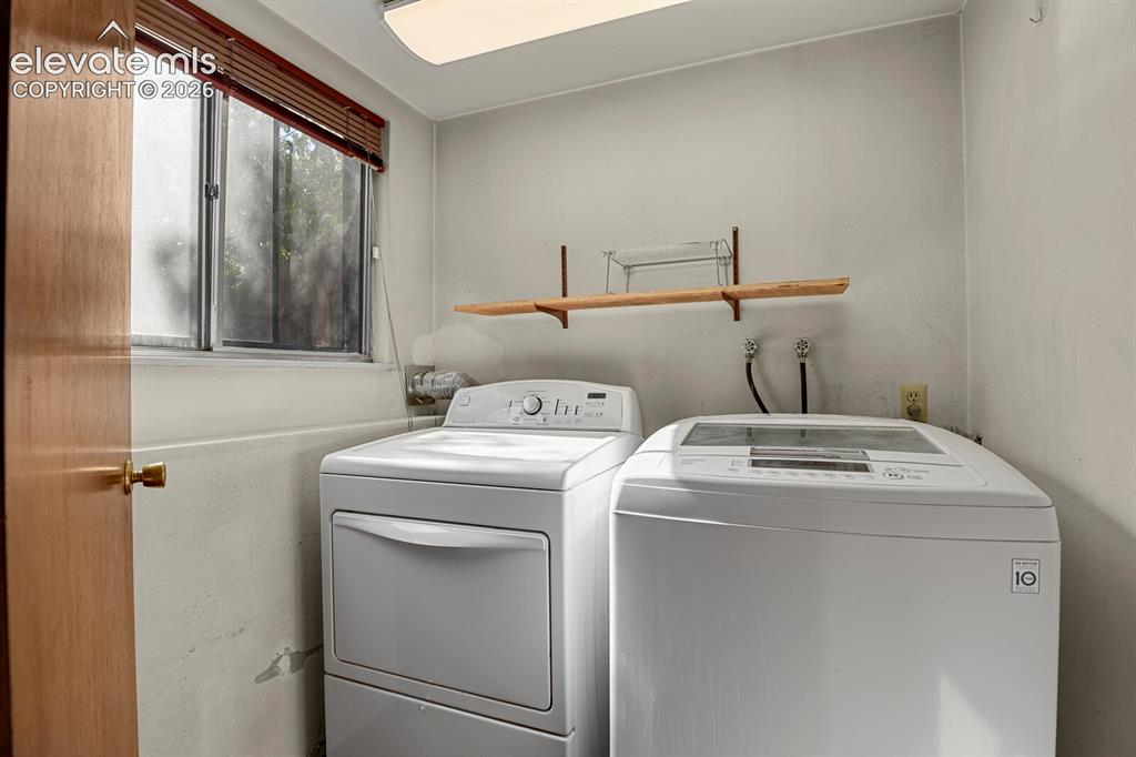 Image 23 of 35: Dedicated laundry area with a window, wood-finish door, and overhead lighti