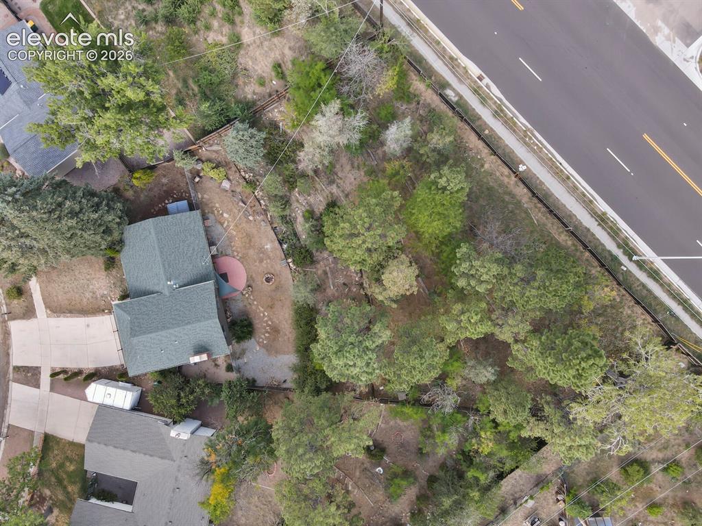 Image 34 of 35: Property featuring a gabled roof, paved driveway, and mature landscaping