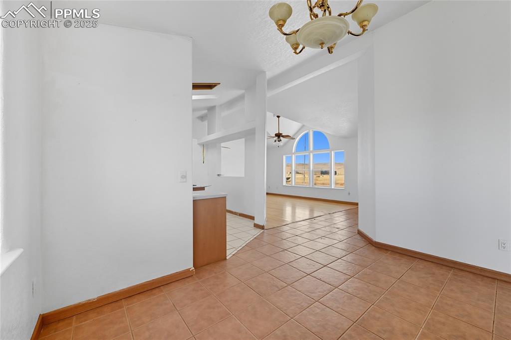 Image 16 of 28: Spare room featuring light tile patterned flooring, a ceiling fan, and a ch