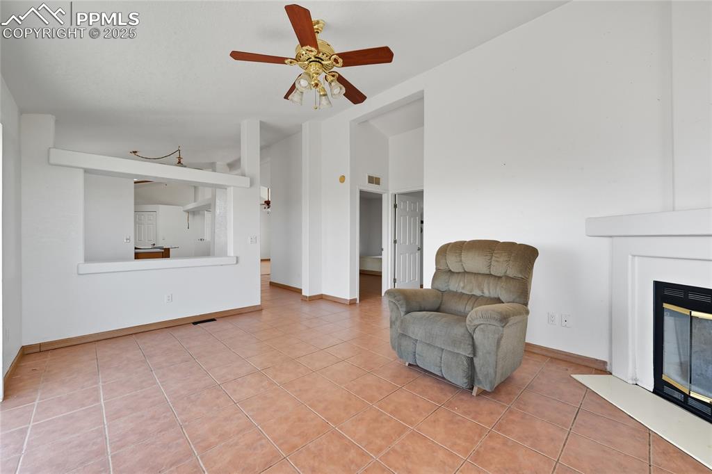 Image 18 of 28: Sitting room featuring light tile patterned floors, a glass covered firepla