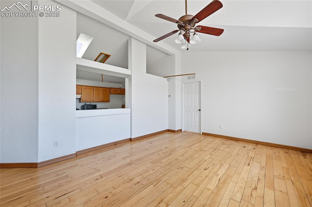 Image 3 of 28: Unfurnished living room featuring light wood finished floors, high vaulted 