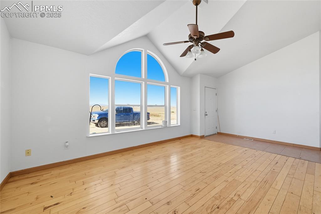 Image 4 of 28: Unfurnished living room with high vaulted ceiling, light wood-type flooring
