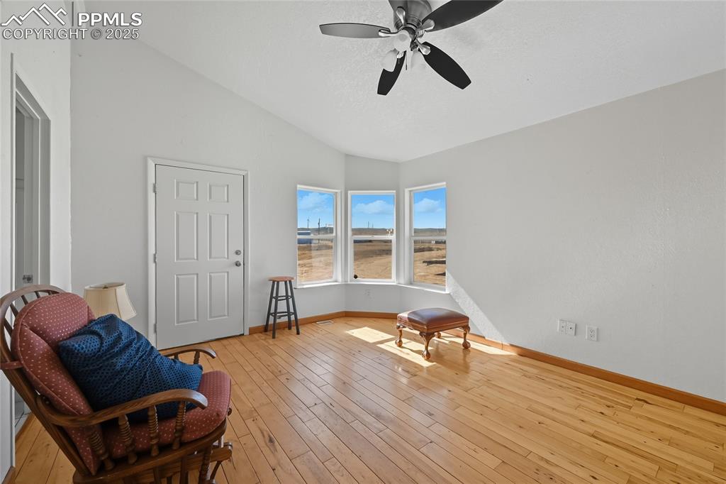 Image 5 of 28: Living area with vaulted ceiling, light wood finished floors, and ceiling f