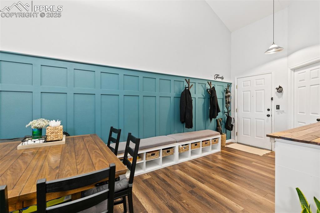 Image 4 of 27: Mudroom with dark wood-style floors, a decorative wall, and a high ceiling