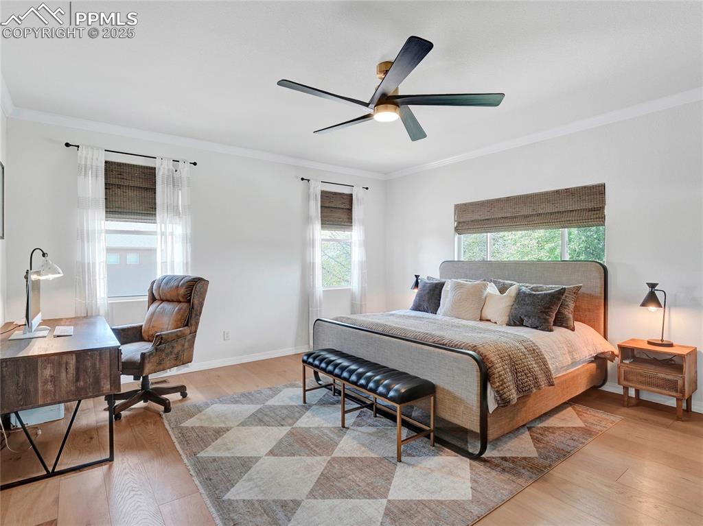 Image 16 of 44: Bedroom featuring ornamental molding, light wood-style floors, a ceiling fa