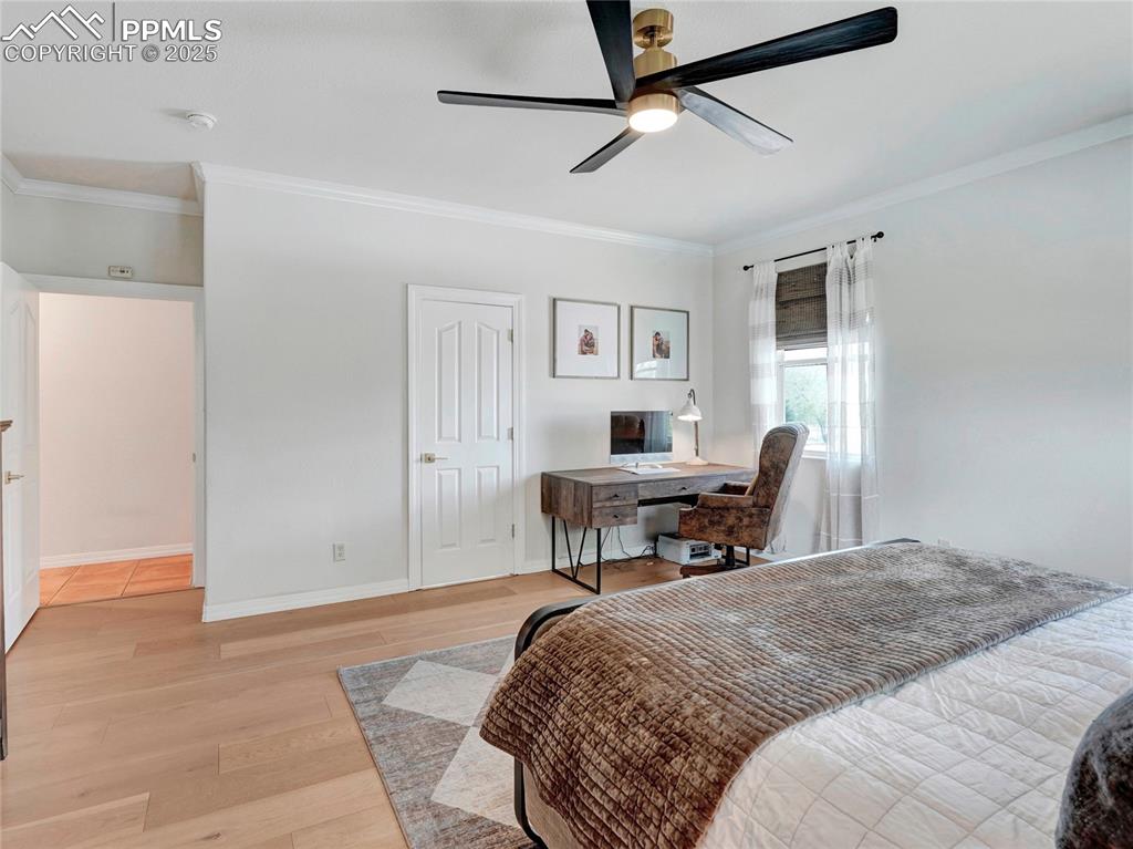 Image 17 of 44: Bedroom featuring crown molding, light wood finished floors, a desk, basebo