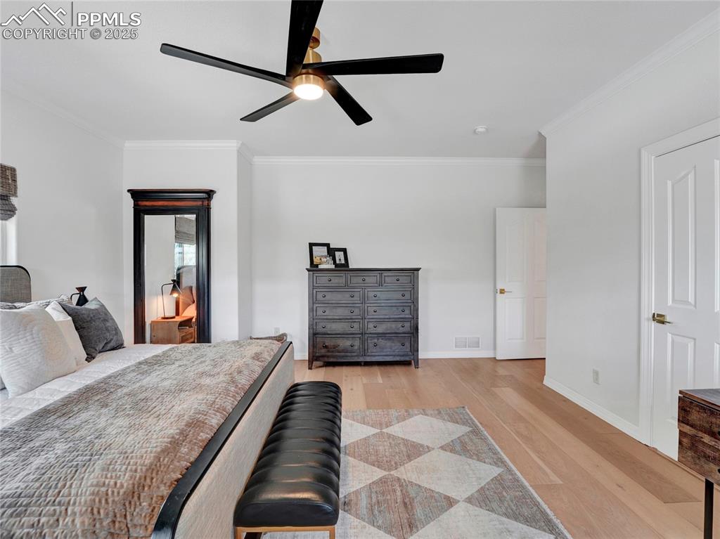 Image 18 of 44: Bedroom featuring light wood-type flooring, crown molding, baseboards, and