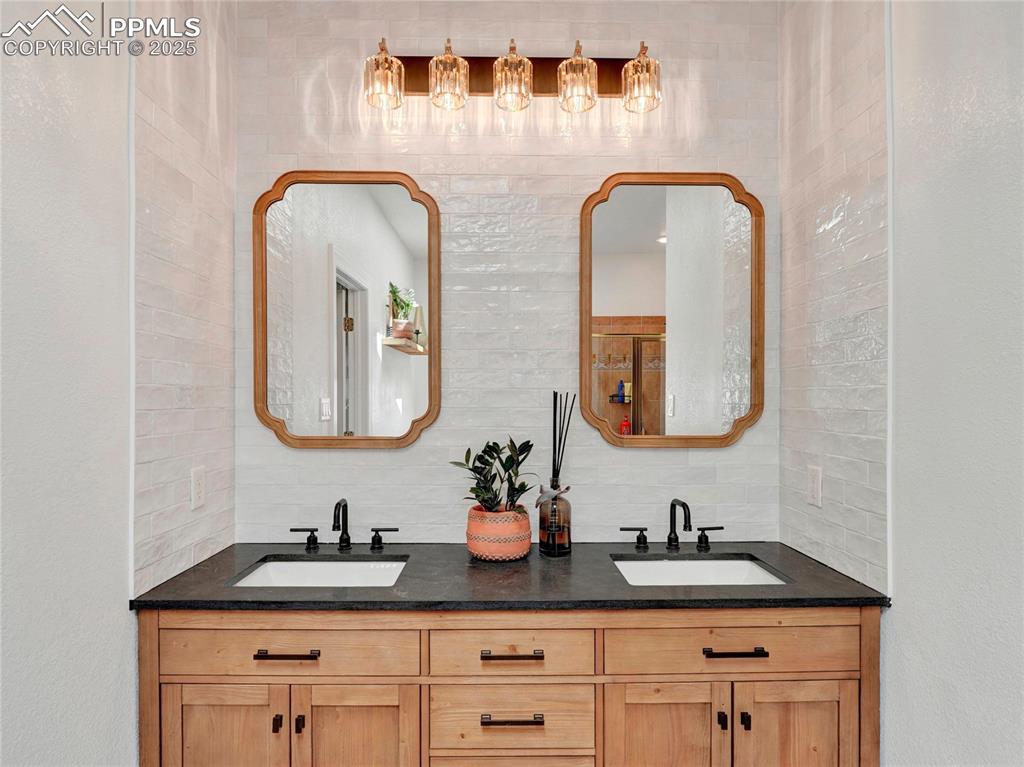 Image 19 of 44: Bathroom featuring decorative backsplash and double vanity