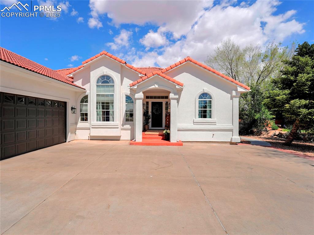 Image 3 of 44: Mediterranean / spanish house with a tile roof, stucco siding, and concrete