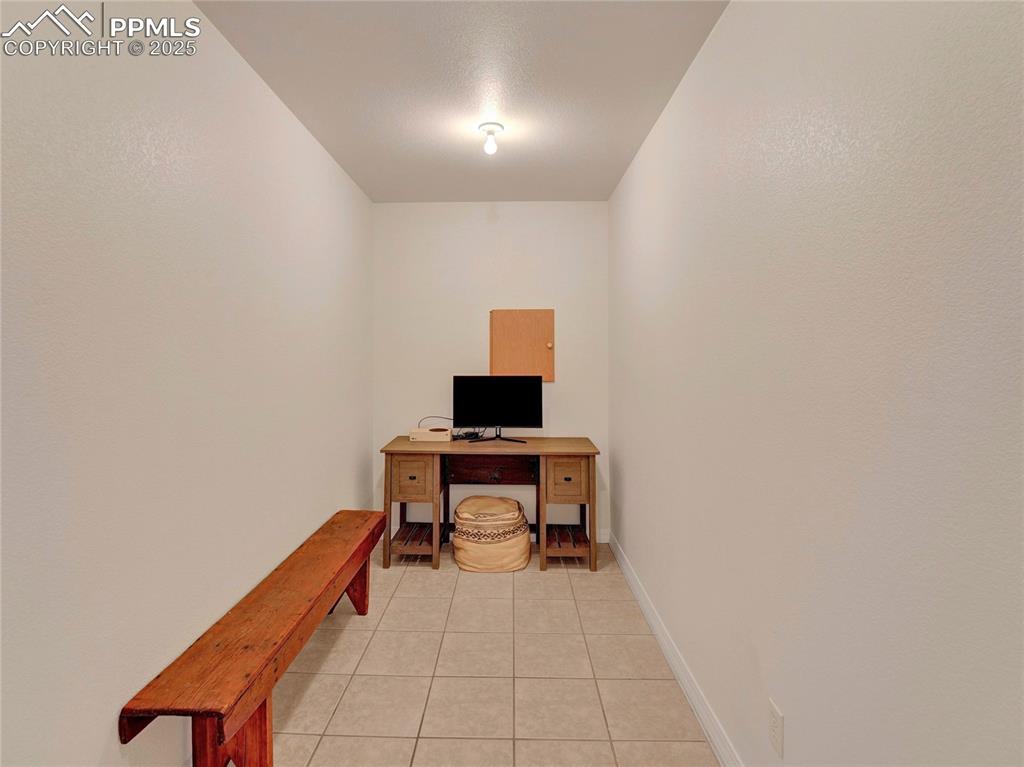 Image 34 of 44: Office featuring light tile patterned floors and baseboards