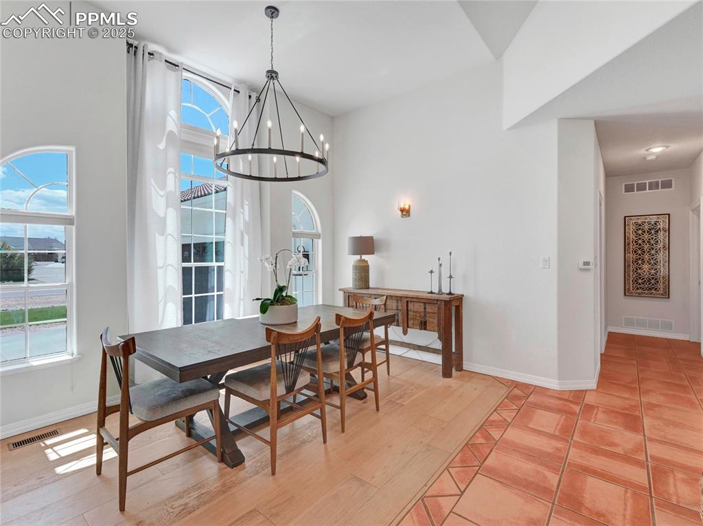Image 8 of 44: Dining space with a chandelier, healthy amount of natural light, and basebo