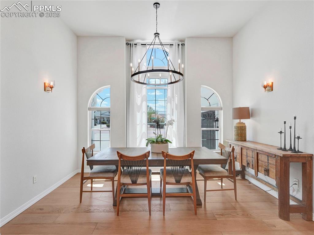 Image 9 of 44: Dining room featuring light wood finished floors, a chandelier, and baseboa