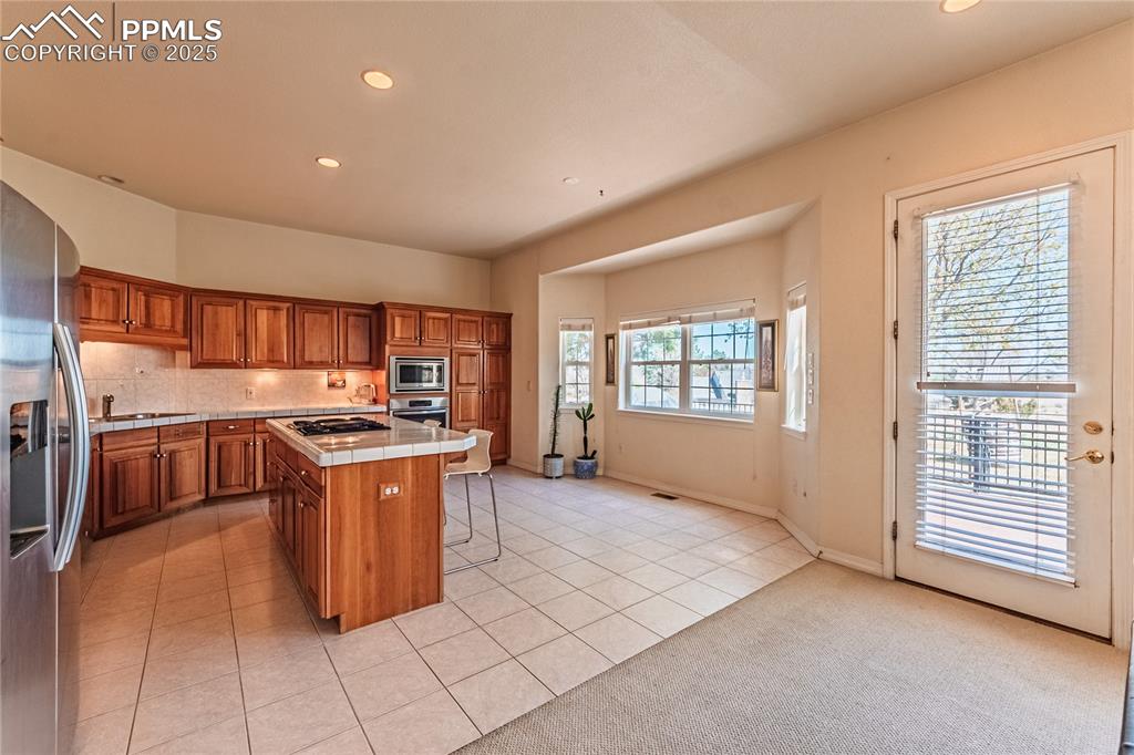 Image 12 of 49: Kitchen with a breakfast bar, a center island, stainless steel appliances, 