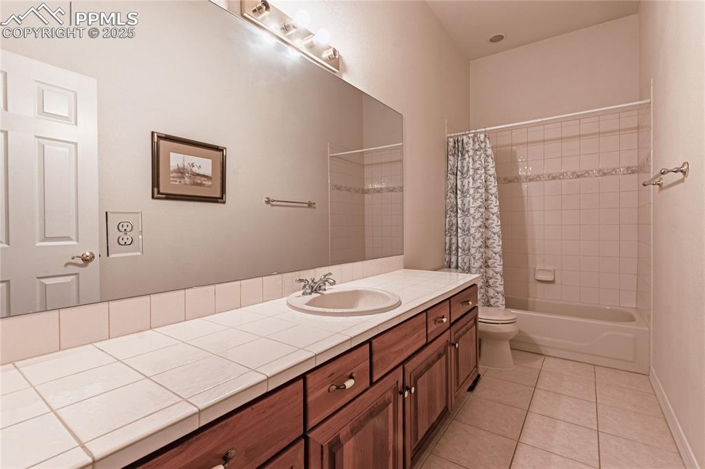 Image 16 of 49: Full bathroom featuring vanity, tile patterned flooring, toilet, shower / b