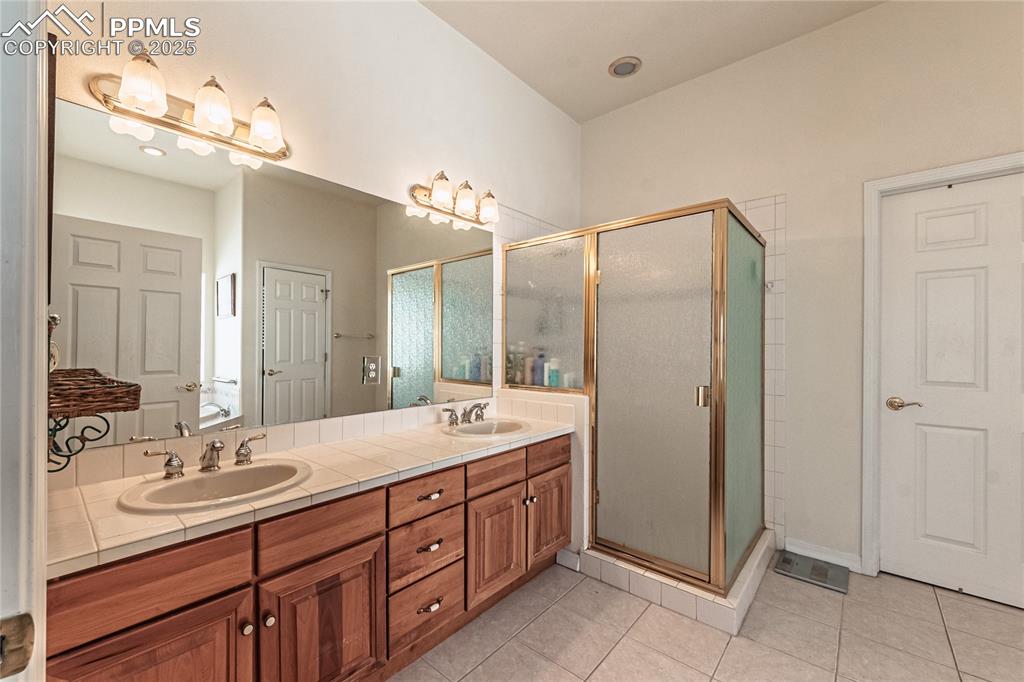 Image 17 of 49: Full bathroom with a shower stall, double vanity, and a sink
