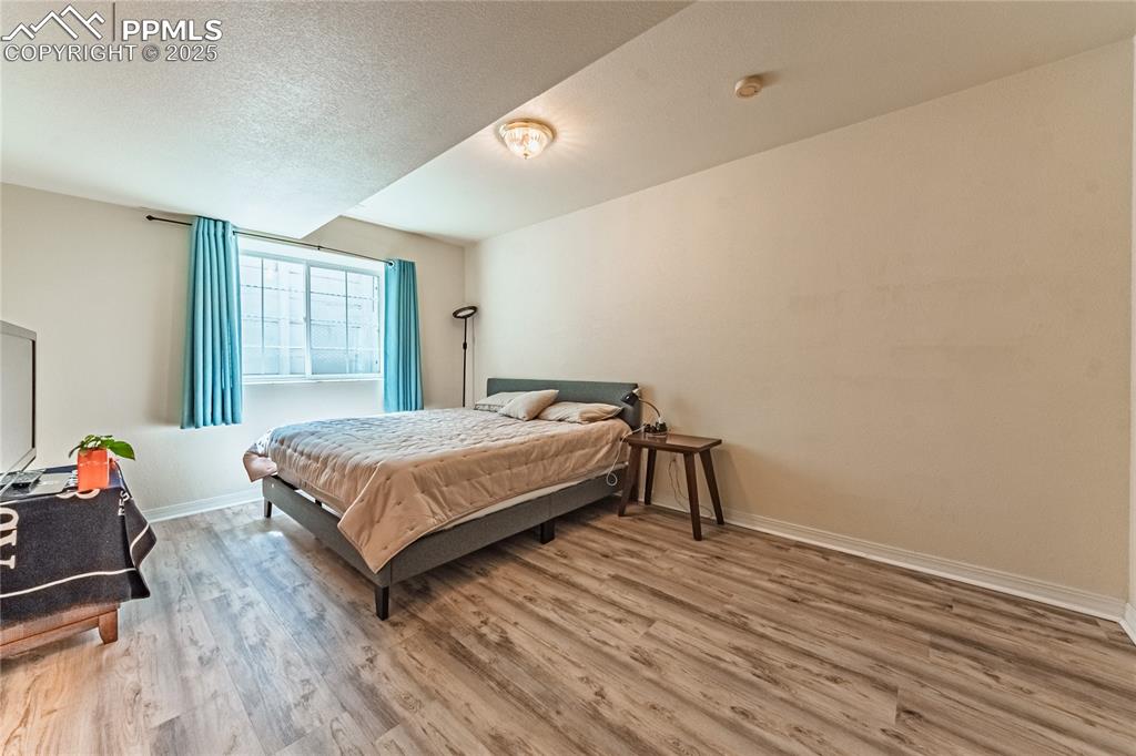 Image 29 of 49: Bedroom featuring baseboards, a textured ceiling, and wood finished floors