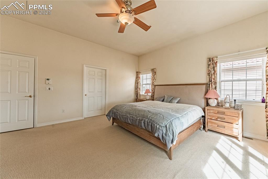 Image 31 of 49: Bedroom featuring light colored carpet, baseboards, and ceiling fan