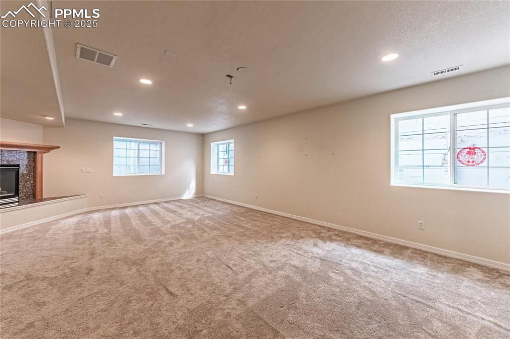 Image 33 of 49: Below grade area with visible vents, recessed lighting, and carpet
