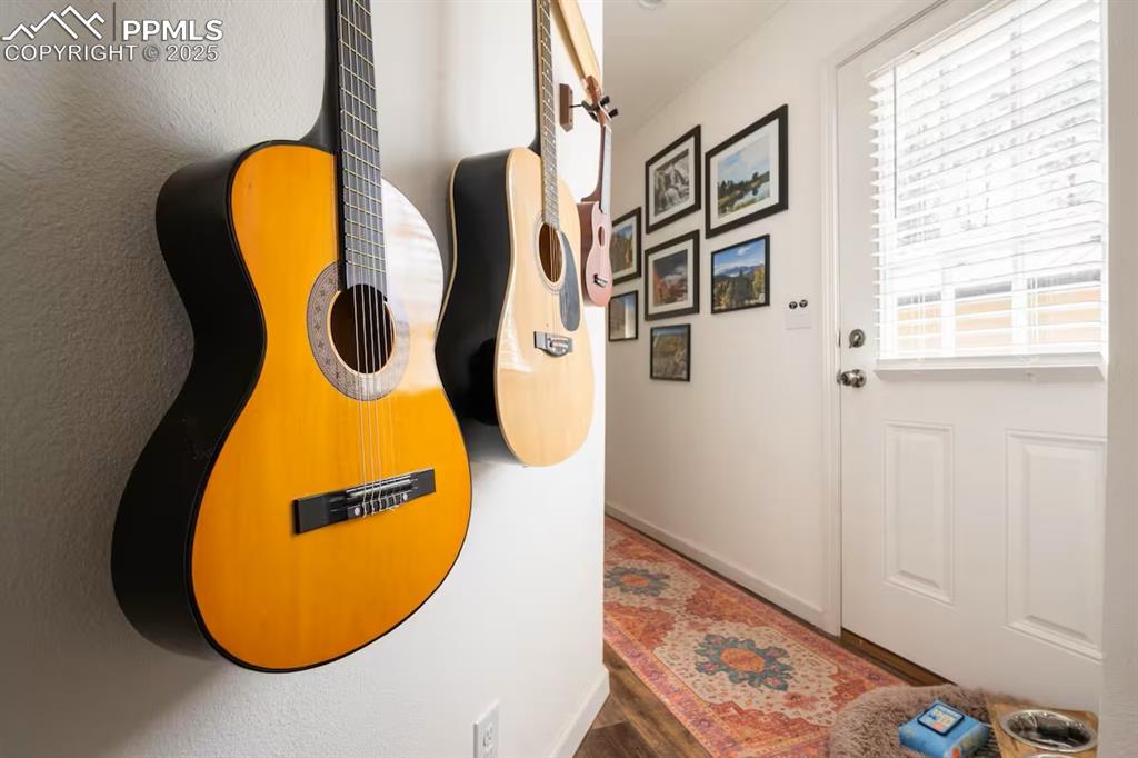 Image 17 of 27: Doorway to outside featuring baseboards and wood finished floors