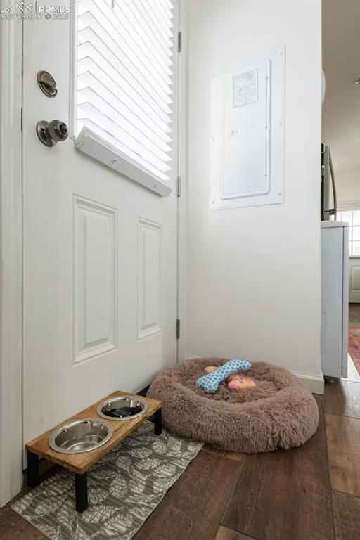 Image 18 of 27: Doorway with electric panel and dark wood finished floors