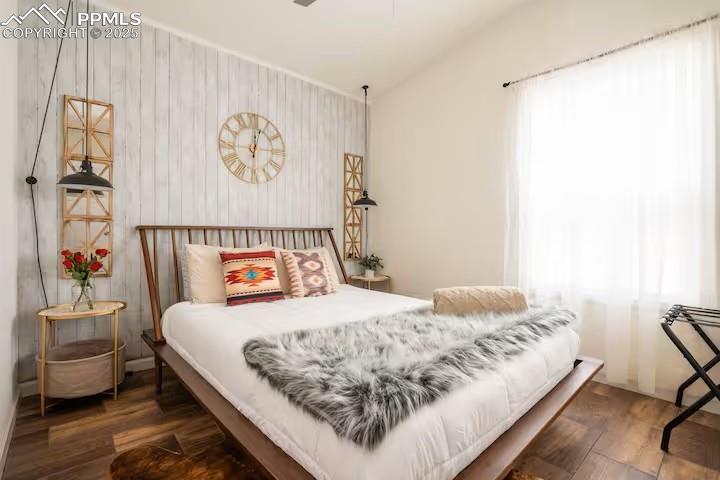 Image 25 of 27: Bedroom with dark wood-style floors