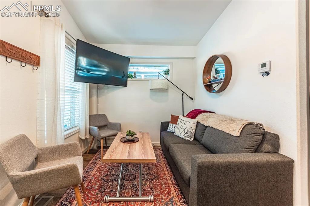 Image 6 of 27: Living area featuring lofted ceiling and visible vents