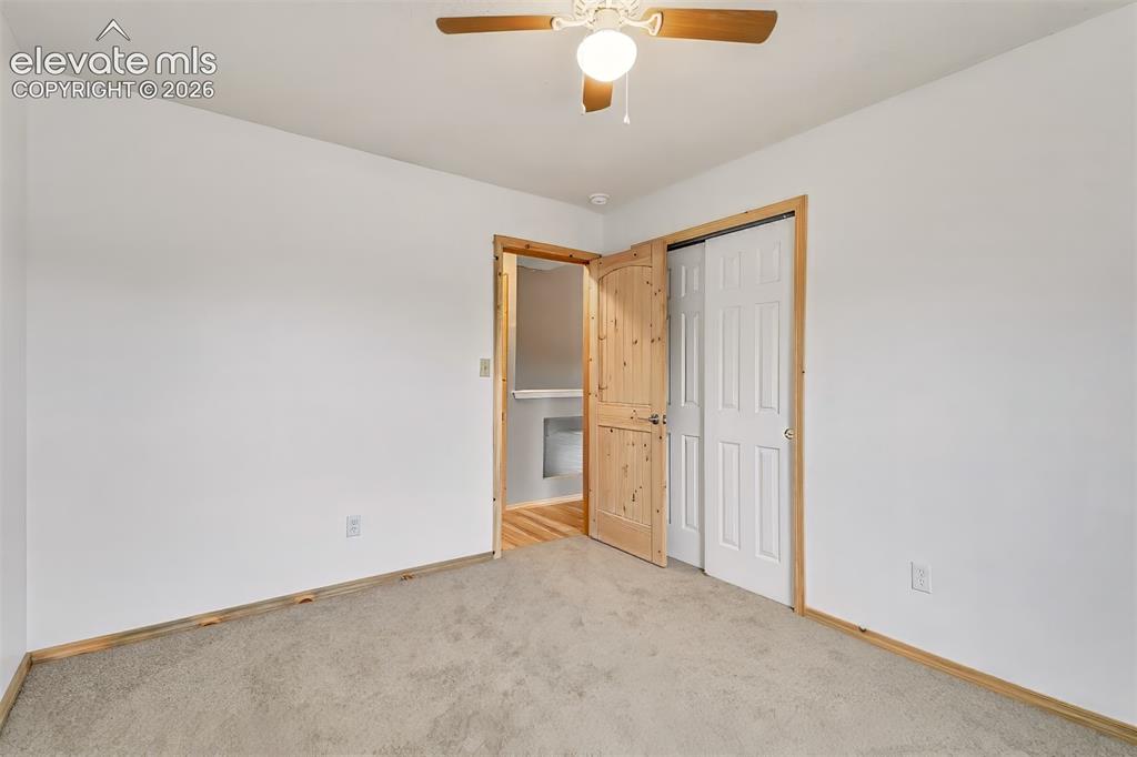 Image 13 of 34: Neutral-toned carpeting, ceiling-mounted light fixture with fan, arched-top