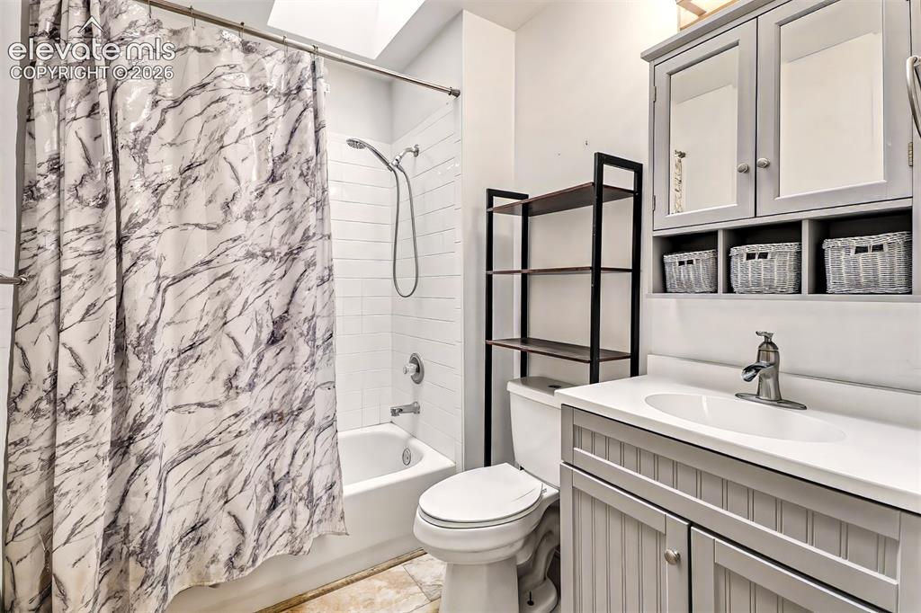 Image 16 of 34: Bathroom featuring a grey beadboard vanity, solid surface countertop with i