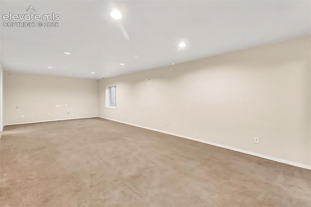 Image 18 of 34: Neutral interior space featuring recessed lighting, carpeting, and a single