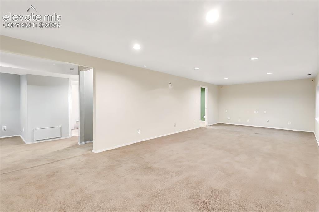 Image 19 of 34: Open-concept interior space featuring neutral wall paint, plush carpeting, 