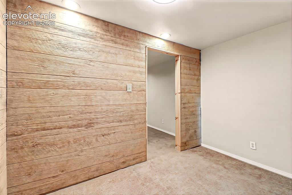 Image 22 of 34: Horizontal wood-plank accent wall with a matching sliding door, recessed ce