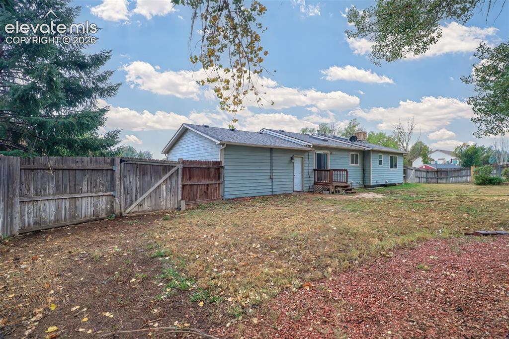 Image 26 of 34: Expansive backyard featuring wood-plank siding, a perimeter wood fence with