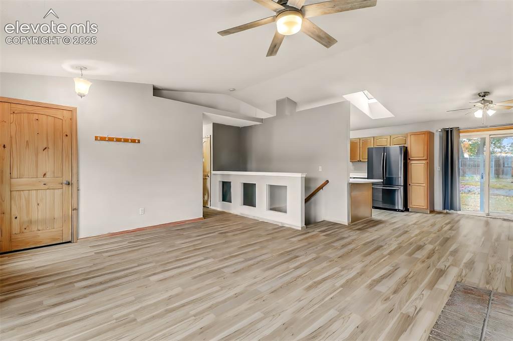 Image 3 of 34: Open-concept interior featuring wood-finish flooring, a vaulted ceiling wit