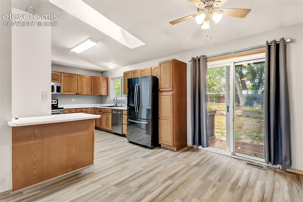 Image 5 of 34: Kitchen featuring wood-finish cabinetry, a peninsula with a countertop, sta