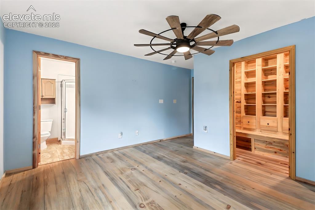 Image 9 of 34: Wood-finish flooring, custom built-in wood shelving, and a prominent multi-