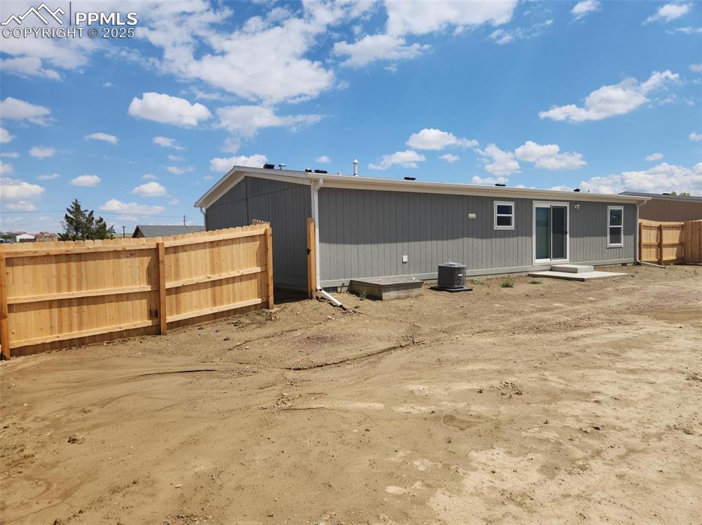 Image 28 of 28: Back of property featuring fence and central AC