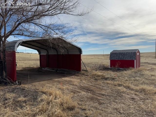Image 12 of 17: View of shed featuring a carport and a view of countryside