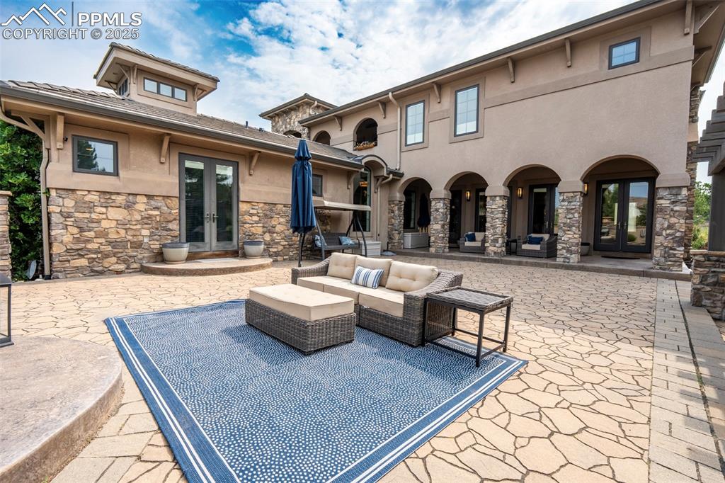 Image 4 of 50: Patio with french doors and an outdoor living space