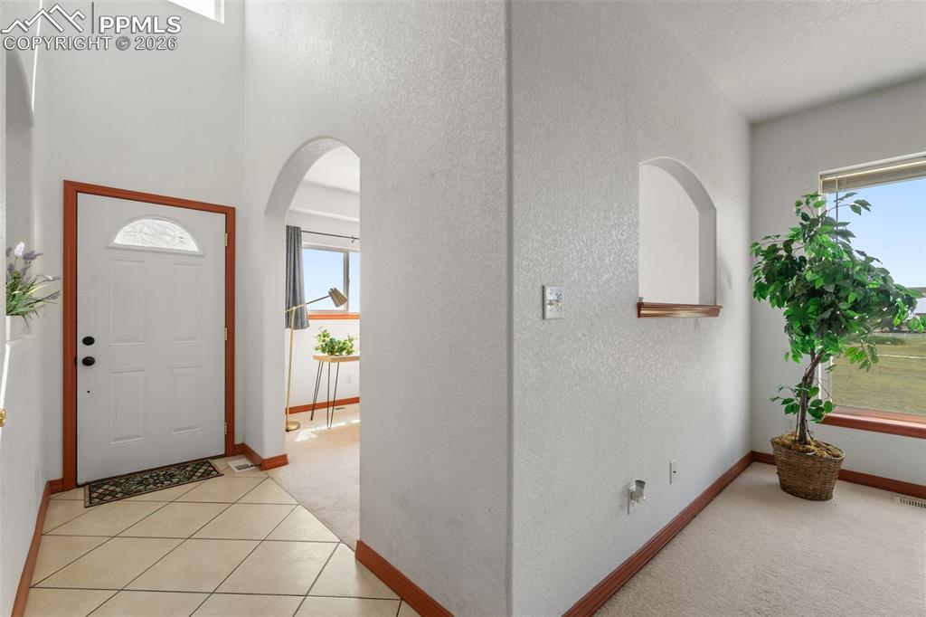 Image 7 of 33: Front door opens to vaulted ceiling