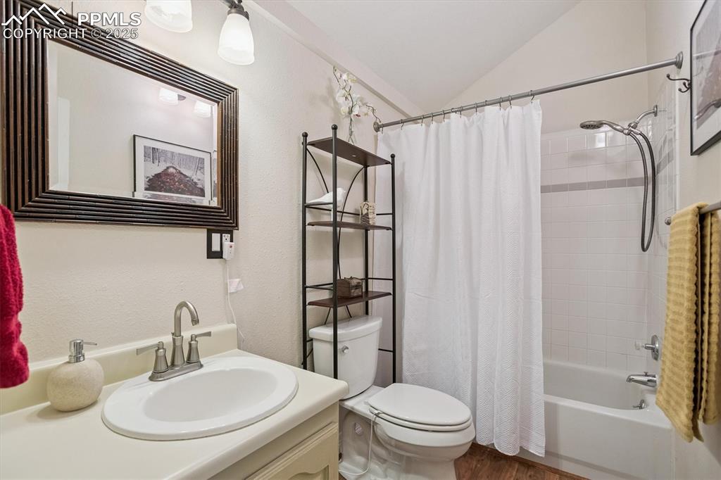 Image 12 of 22: Full bath with shower / bath combo with shower curtain, vanity, vaulted cei
