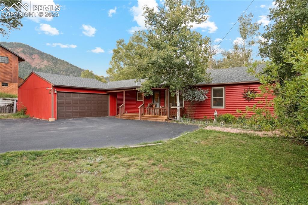 Image 14 of 22: Ranch-style house featuring an attached garage, a shingled roof, a front ya